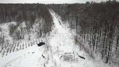 越野车6x6的鸟瞰图，在冬季森林的雪覆盖道路上行驶